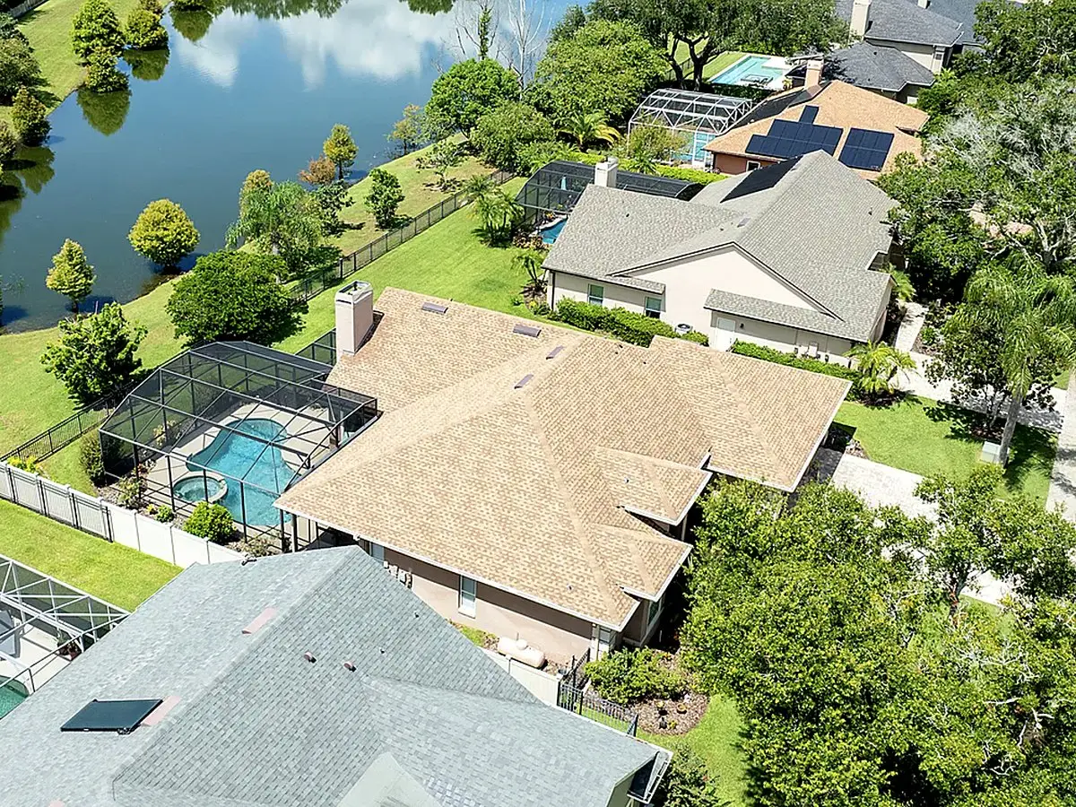 Aerial view of a lakefront pool home with a shingle roof, Conway roofing service area